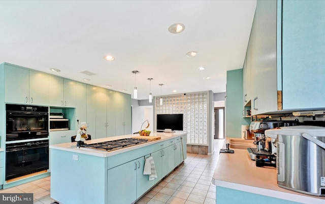 kitchen with light tile patterned floors, a kitchen island, dobule oven black, and gas stovetop