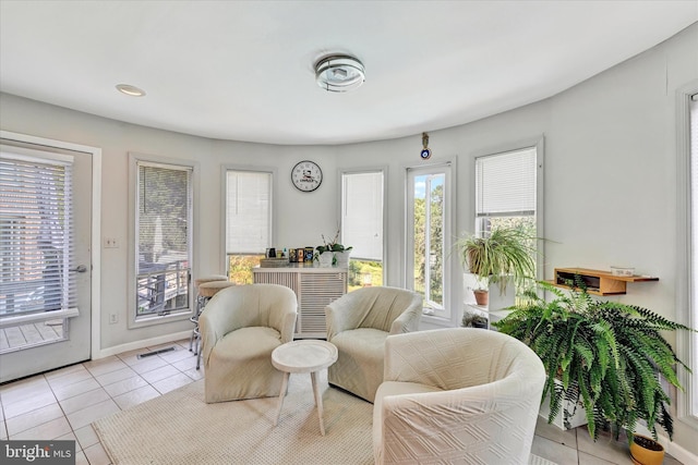 living area with light tile patterned floors, visible vents, and baseboards