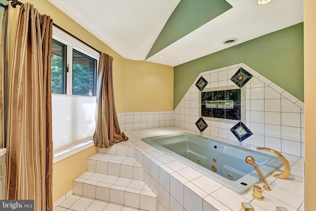 bathroom with lofted ceiling and a tub with jets