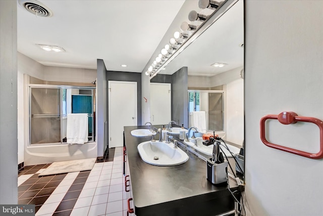 bathroom featuring a sink, tile patterned floors, visible vents, and enclosed tub / shower combo