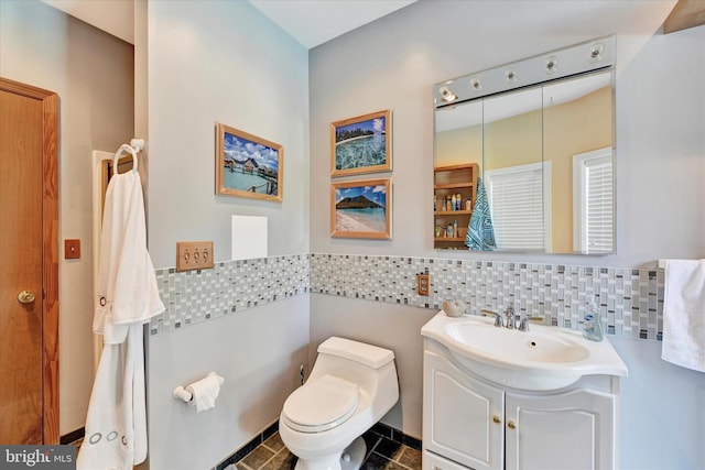 bathroom with vanity, decorative backsplash, and toilet