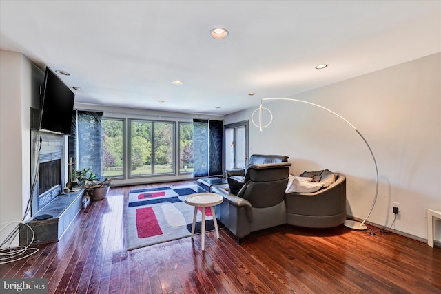 living room featuring recessed lighting, wood-type flooring, and a tile fireplace