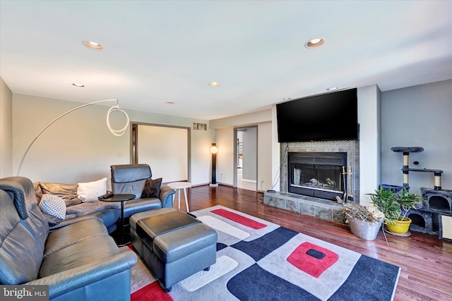 living area featuring a fireplace, recessed lighting, wood finished floors, and visible vents