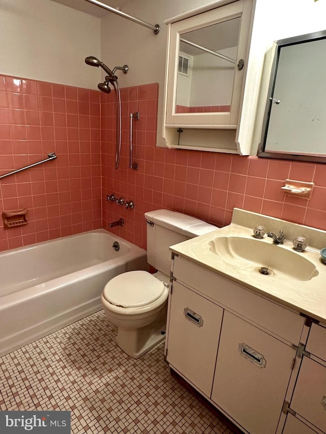 full bathroom with vanity, tiled shower / bath, tile patterned flooring, tile walls, and tasteful backsplash