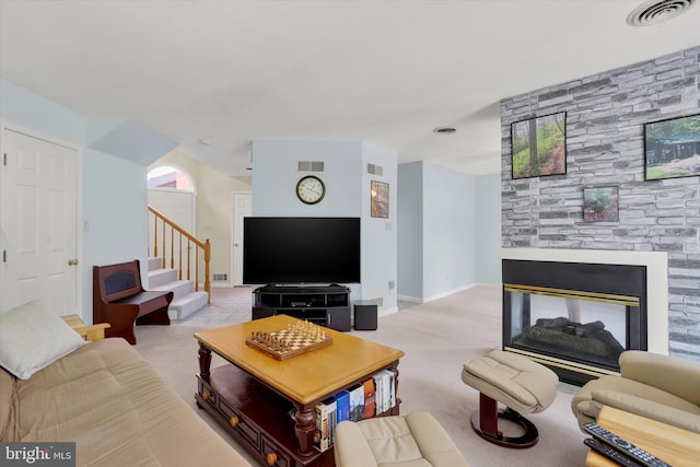 carpeted living room with a stone fireplace