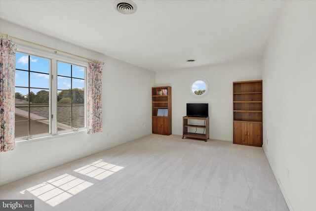 unfurnished living room featuring light carpet