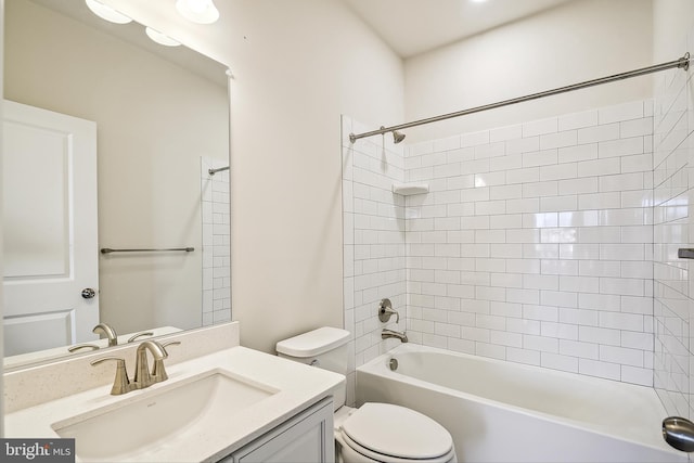 full bathroom featuring tiled shower / bath combo, vanity, and toilet