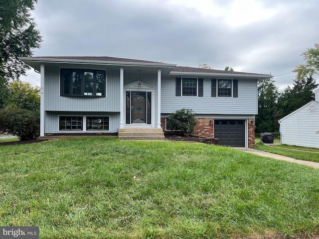 bi-level home with a garage and a front lawn