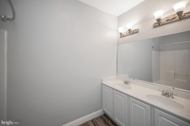 bathroom featuring vanity, wood-type flooring, and a textured ceiling