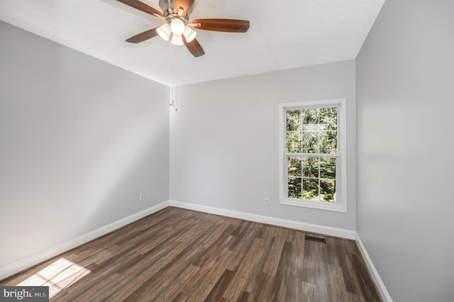 empty room featuring ceiling fan, dark wood-type flooring, and a textured ceiling