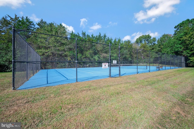 view of tennis court featuring a lawn