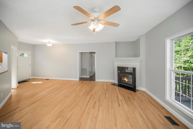 unfurnished living room featuring ceiling fan and light wood-type flooring