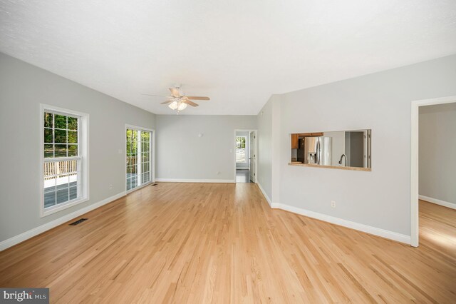 unfurnished living room with light hardwood / wood-style flooring and ceiling fan