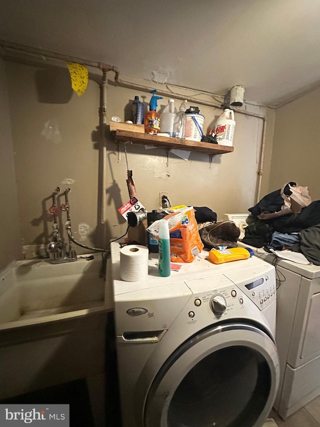 clothes washing area featuring washing machine and dryer and sink