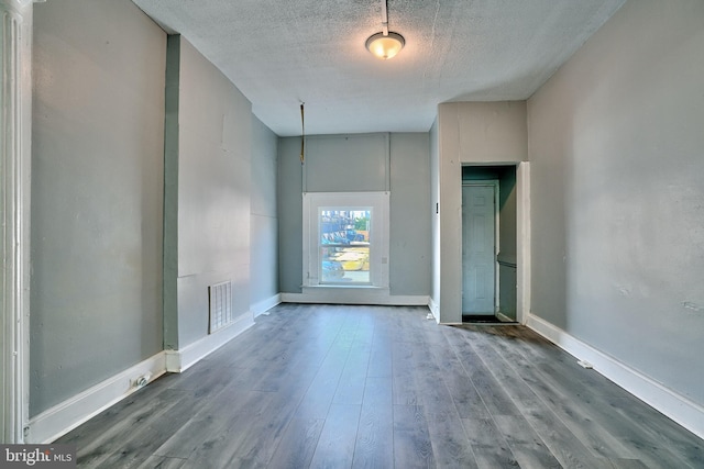 spare room featuring hardwood / wood-style floors and a textured ceiling