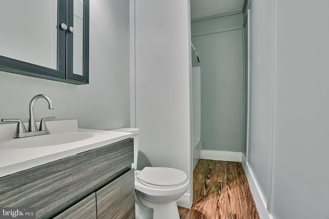 bathroom with hardwood / wood-style floors, toilet, and vanity