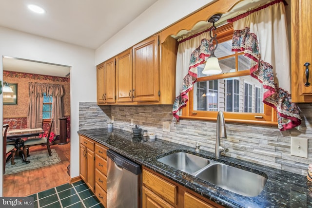 kitchen featuring dishwasher, tasteful backsplash, sink, dark hardwood / wood-style flooring, and dark stone countertops