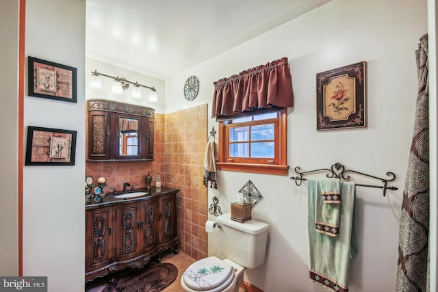 bathroom with vanity, tile walls, and toilet