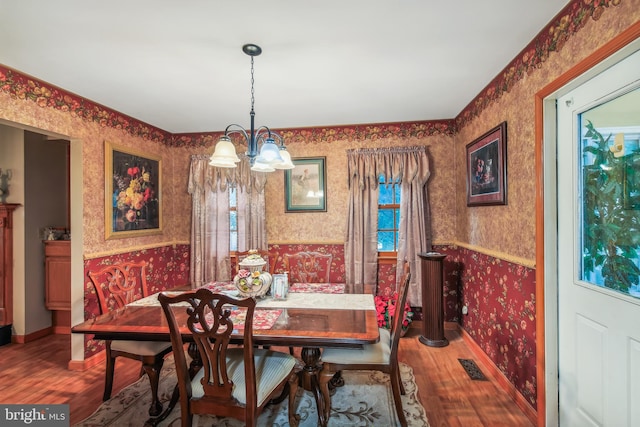 dining area featuring wood-type flooring and a chandelier