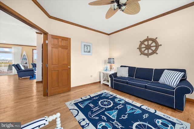 living room featuring crown molding, hardwood / wood-style flooring, and ceiling fan