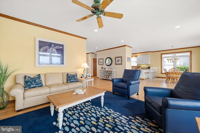 living room featuring crown molding, hardwood / wood-style flooring, and ceiling fan with notable chandelier