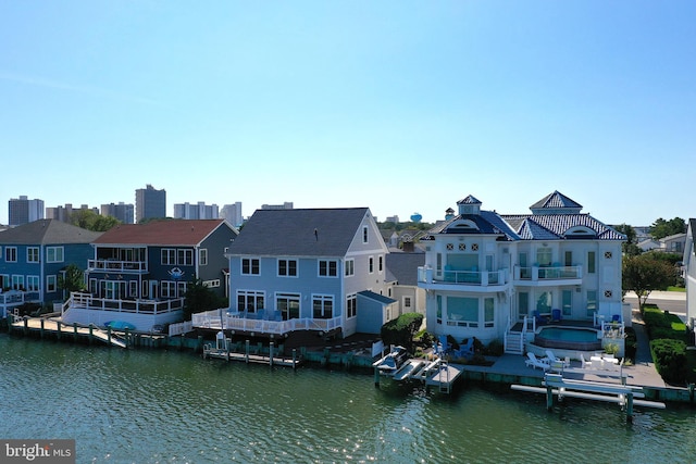 rear view of house featuring a water view and a balcony