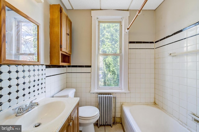 full bathroom featuring vanity, radiator, tile walls, toilet, and tile patterned floors