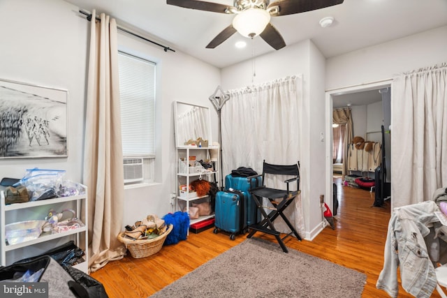 bedroom featuring cooling unit, ceiling fan, and wood finished floors