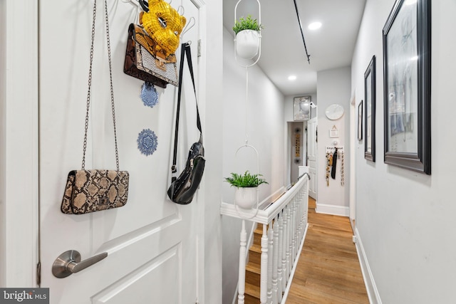 hallway featuring recessed lighting, baseboards, and light wood-style flooring