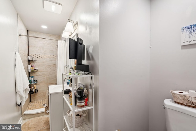 full bathroom featuring tile patterned floors, toilet, a sink, and a tile shower