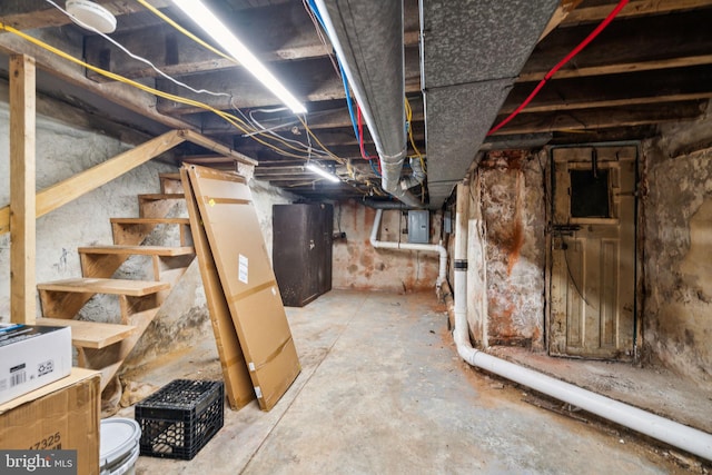 unfinished basement with stairway and electric panel