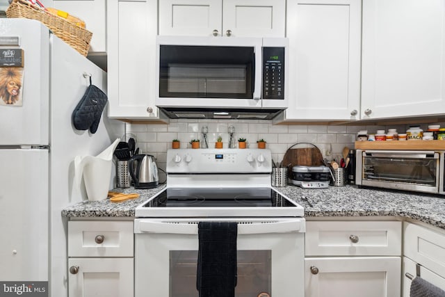 kitchen with white appliances, white cabinets, a toaster, and tasteful backsplash