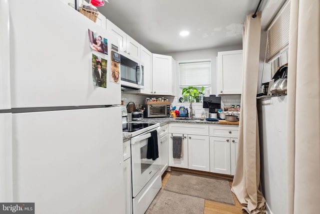 kitchen with tasteful backsplash, a toaster, white appliances, white cabinetry, and a sink