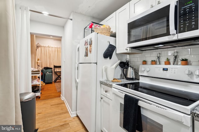 kitchen featuring decorative backsplash, white cabinets, white appliances, and light wood-type flooring