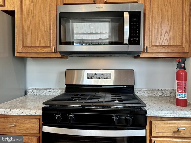 kitchen with light stone countertops and appliances with stainless steel finishes