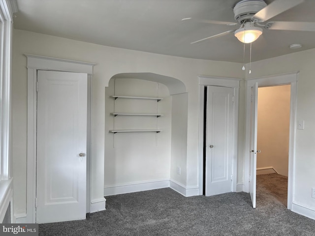 unfurnished bedroom with dark colored carpet and ceiling fan