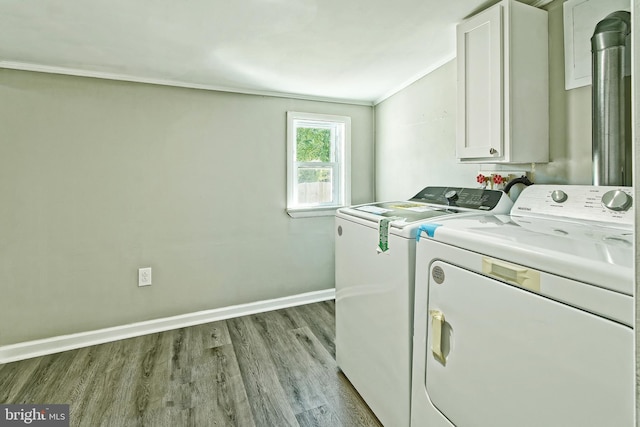 washroom featuring ornamental molding, light hardwood / wood-style floors, cabinets, and washing machine and dryer