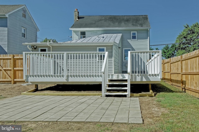 back of property featuring a wooden deck and a patio area