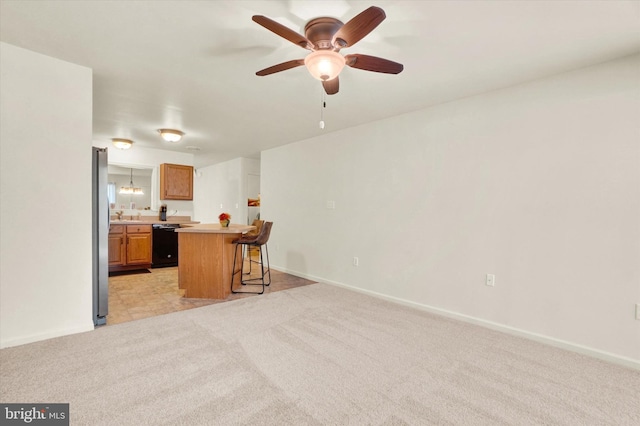 kitchen with dishwasher, light carpet, ceiling fan, and a breakfast bar