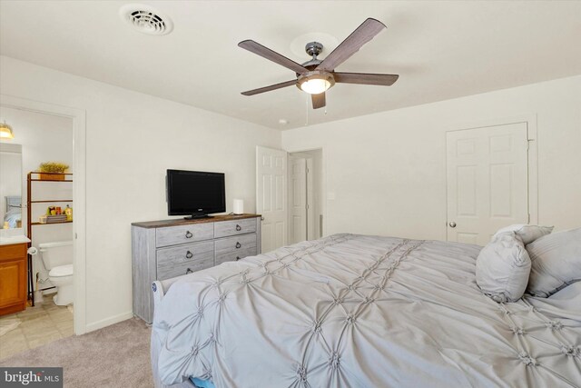 carpeted bedroom with ceiling fan and connected bathroom