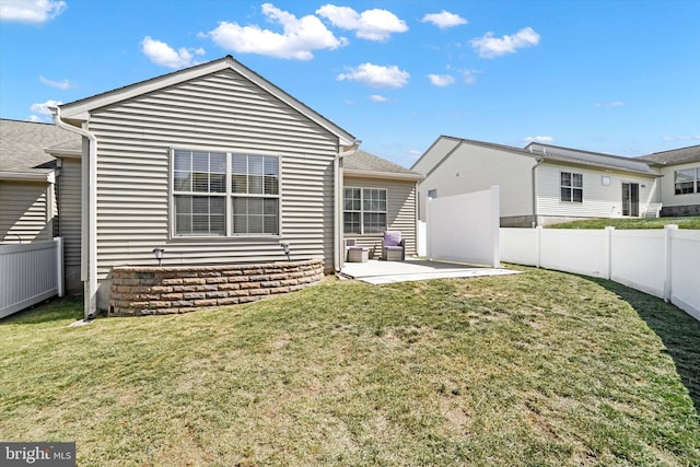 back of property with a yard and a patio