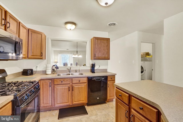 kitchen with an inviting chandelier, black appliances, washer / clothes dryer, hanging light fixtures, and sink