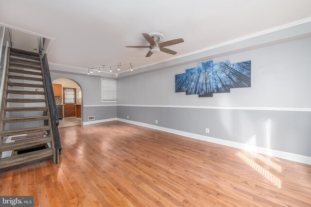 unfurnished living room with ornamental molding, ceiling fan, hardwood / wood-style flooring, and rail lighting