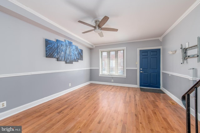 foyer entrance with ceiling fan, light wood-type flooring, and crown molding