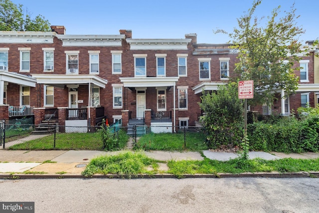 view of property with a fenced front yard and brick siding