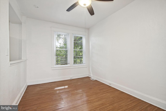 unfurnished room featuring a ceiling fan, lofted ceiling, baseboards, and wood finished floors