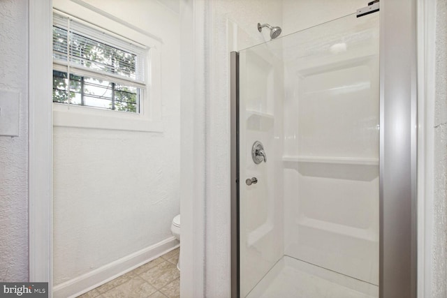 full bathroom with a shower stall, toilet, baseboards, and tile patterned floors