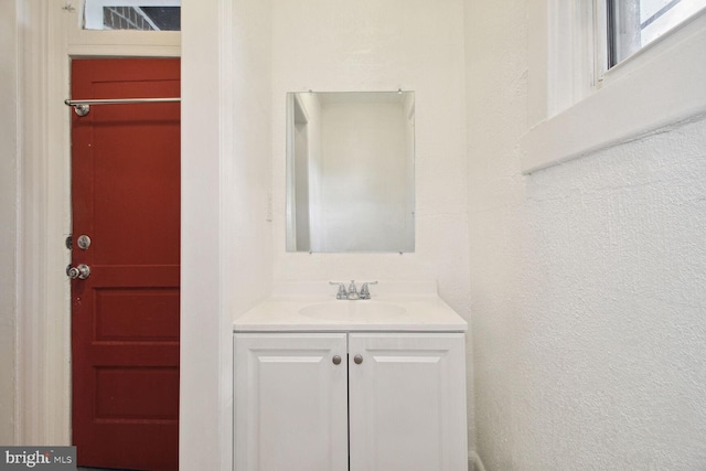 bathroom with vanity and a textured wall