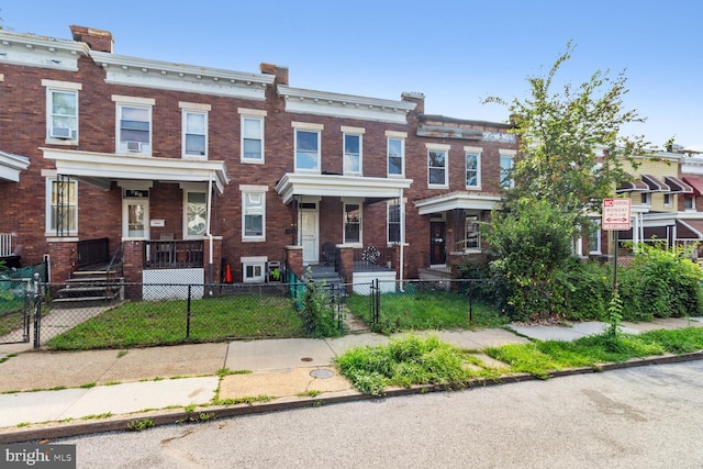 view of property with a gate, brick siding, and a fenced front yard