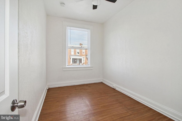 spare room featuring ceiling fan, baseboards, and wood finished floors